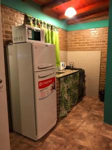 una cucina con frigorifero e forno a microonde in cima di Departamentos la Familia NONO a Nono