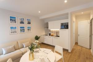 a living room with a white couch and a table at Ca' Benedetta Suite House by ApartSuite in Sottomarina
