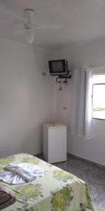 a bedroom with a bed and a tv on the wall at Pousada São Francisco in Morretes