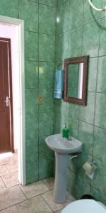 a bathroom with a sink and a mirror and a toilet at Pousada São Francisco in Morretes