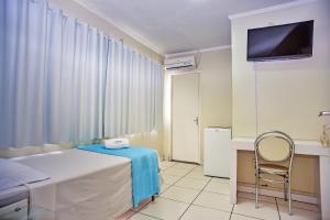 a bedroom with a bed and a tv and a chair at Exclusive Hotel in Petrolina