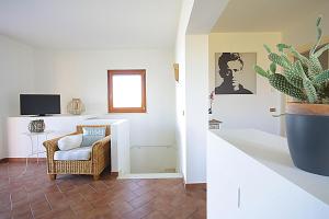 a living room with a chair and a plant at La Villa Degli Ulivi in Soiano del Lago