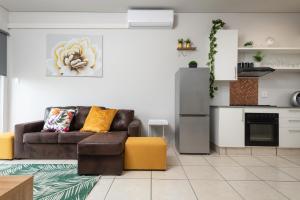sala de estar con sofá marrón y cocina en Ballito Luxury Apartment, en Ballito