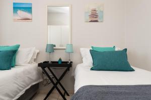 um quarto com 2 camas e uma mesa com um espelho em Ballito Luxury Apartment em Ballito