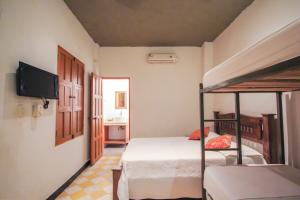 a bedroom with a bunk bed and a television at Hotel Casa Sarah in Santa Marta
