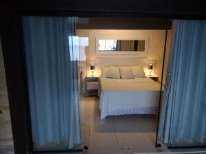 a bedroom with a bed and a window at Coco Beach Apart 5B in Natal