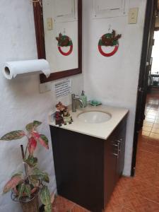 a bathroom sink with christmas wreaths on the wall at Casa Irazu in Cartago