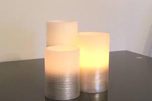 tres velas blancas sentadas sobre una mesa en The Annex at Bonnieview en Inverness