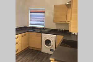 a kitchen with a washing machine and a window at The Annex at Bonnieview in Inverness