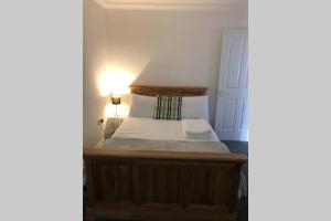 a bedroom with a wooden bed with a light on it at The Annex at Bonnieview in Inverness