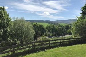 a fence with a view of a field behind it at The Annex at Bonnieview in Inverness