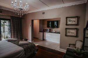 um quarto com uma cama e um lustre em Le Grant Guesthhouse em Kroonstad