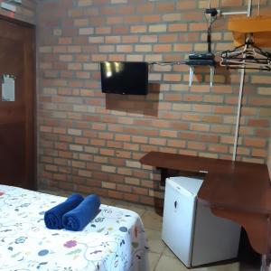 Habitación con cama, mesa y pared en Pousada do Riacho en Barreirinhas