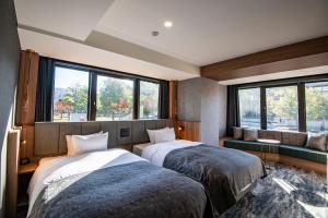 2 camas en una habitación con ventanas en AN-GRANDEホテル奈良, en Nara