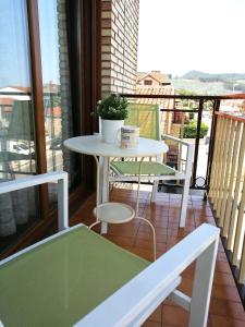 a balcony with a table and chairs on a balcony at APARTAMENTO RIO AGÜERA EN GURIEZO, next to Castro Urdiales y Bilbao in Adino