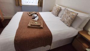 a hotel room with a bed with two towels on it at Sunnydale in Blackpool