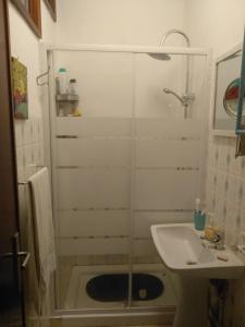 a shower with a glass door next to a sink at my secret beach... in Vila Chã