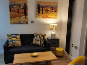 a living room with a black couch and a table at The Barn in Swaffham