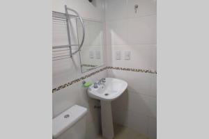 een witte badkamer met een wastafel en een spiegel bij home rent in La Plata