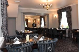 a dining room with tables and chairs and a mirror at The Llanelwedd Arms Hotel in Builth Wells