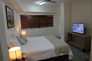 a bedroom with a bed and a flat screen tv at Darwin Deluxe Apartments in Darwin +28 photos