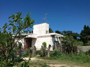 un edificio blanco con una cruz encima en Milk-ya Women-Only Guest House, en Yomitan