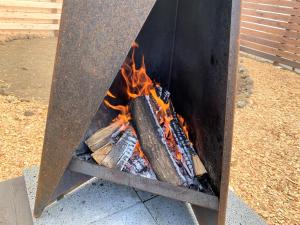 a fire in a grill with flames in it at CAMP＆COTTAGE THE DOOR in Fujikawaguchiko