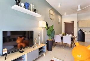 sala de estar con TV grande y comedor en Tropical Houz@Midhill Genting Highlands (Free Wi-Fi), en Genting Highlands