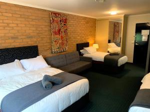 a hotel room with two beds and a couch at Attunga Alpine Lodge & Apartments in Falls Creek