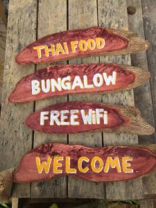 een bord op een muur dat leest dat voedsel burritoflow gratis wifi welkom bij Phayam Garden View in Ko Phayam