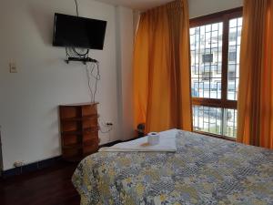 a bedroom with a bed and a tv and a window at EL ENSUEÑO in Lima