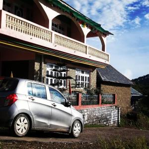 a silver car parked in front of a building at Ritu Raj Home Stay & Cafe in Malther
