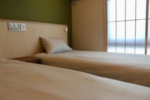 a room with two beds and a window at HIZ HOTEL Gion-Shirakawa in Kyoto