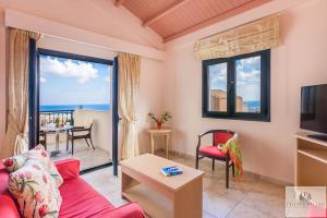 a living room with a red couch and a tv at Pilot's Villas Luxury Suites in Hersonissos