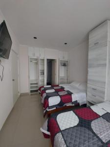 eine Reihe von Betten in einem Zimmer in der Unterkunft Tempu Departamento ejecutivo en Piura in Piura