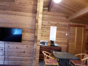 a living room with a table and a tv on a wall at Rocky Inn in Valemount