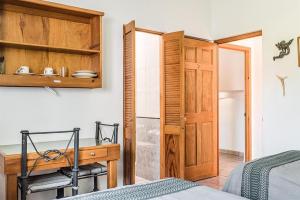 a bedroom with a desk and a wooden door at Posada de los Angeles in Oaxaca City