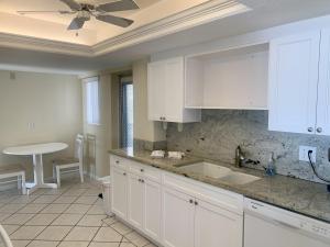 a kitchen with white cabinets and a sink at Island House Beach Resort 3N in Siesta Key