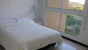 a bedroom with a bed and a large window at Hermoso Apto con vista a la sierra y a Cabo Tortuga en el sector del Irotama en Santa Marta in Gaira +19 photos