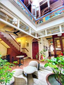 - un bâtiment avec une terrasse dotée d'une table et de chaises dans l'établissement Nam Keng Hotel Penang, à George Town