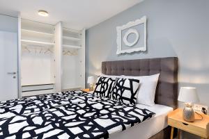 a bedroom with a bed with a black and white comforter at Charming Place near Centre with GARAGE parking in Zagreb