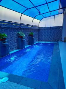 an indoor swimming pool with blue water in a building at VILLA MB in Bogor
