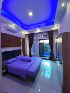 a bedroom with a bed with a blue ceiling at VILLA MB in Bogor