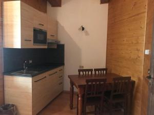 a kitchen with a wooden table with chairs and a sink at Hotel La Pigna in Bardonecchia