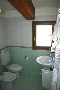 La salle de bains est pourvue de toilettes et d'un lavabo. dans l'établissement Hotel La Pigna, à Bardonnèche