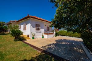 a white house with a large yard in front of it at Messinia - George Cottage in Kalamata