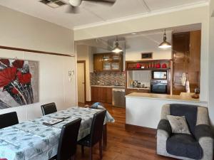 a dining room and kitchen with a table and chairs at Trippypossums House in Horsham