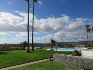 una piscina con palmeras en un parque en Villa in Duna Golf, en Playa del Inglés