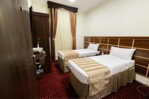 Yasmin Al Majd Hotel في مكة المكرمة: غرفة فندقية بسريرين ونافذة