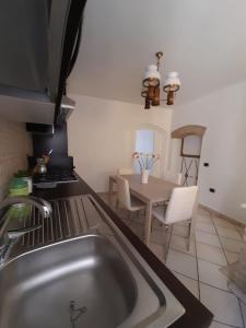 a kitchen with a sink and a table with chairs at B&B InCentro in Ripatransone